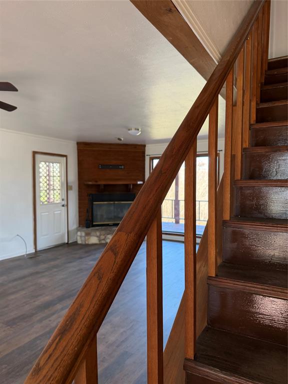 263 Highway 154 Ringgold, LA 71068 - Photo 6 of 38 Staircase featuring ornamental molding, a glass covered fireplace, wood finished floors, and a ceiling fan