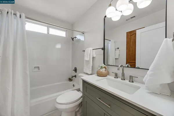 a bathroom with a sink a toilet and a large mirror