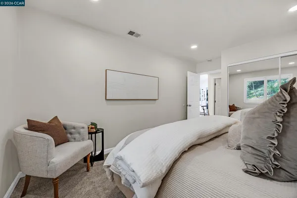 a spacious bedroom with a bed a couch and a window