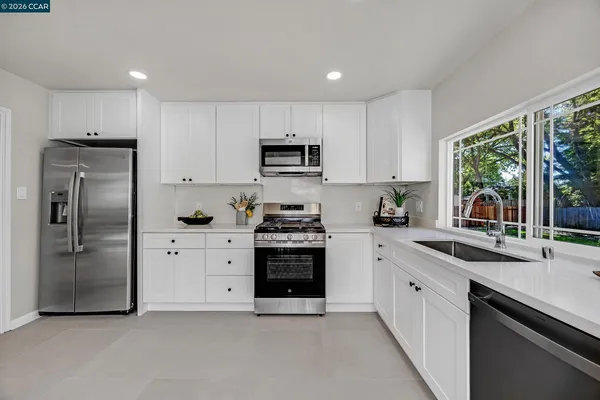 a kitchen with stainless steel appliances granite countertop a stove a sink and a refrigerator