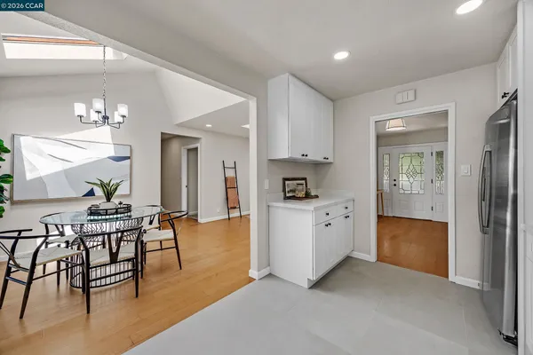 a kitchen with white cabinets and chairs