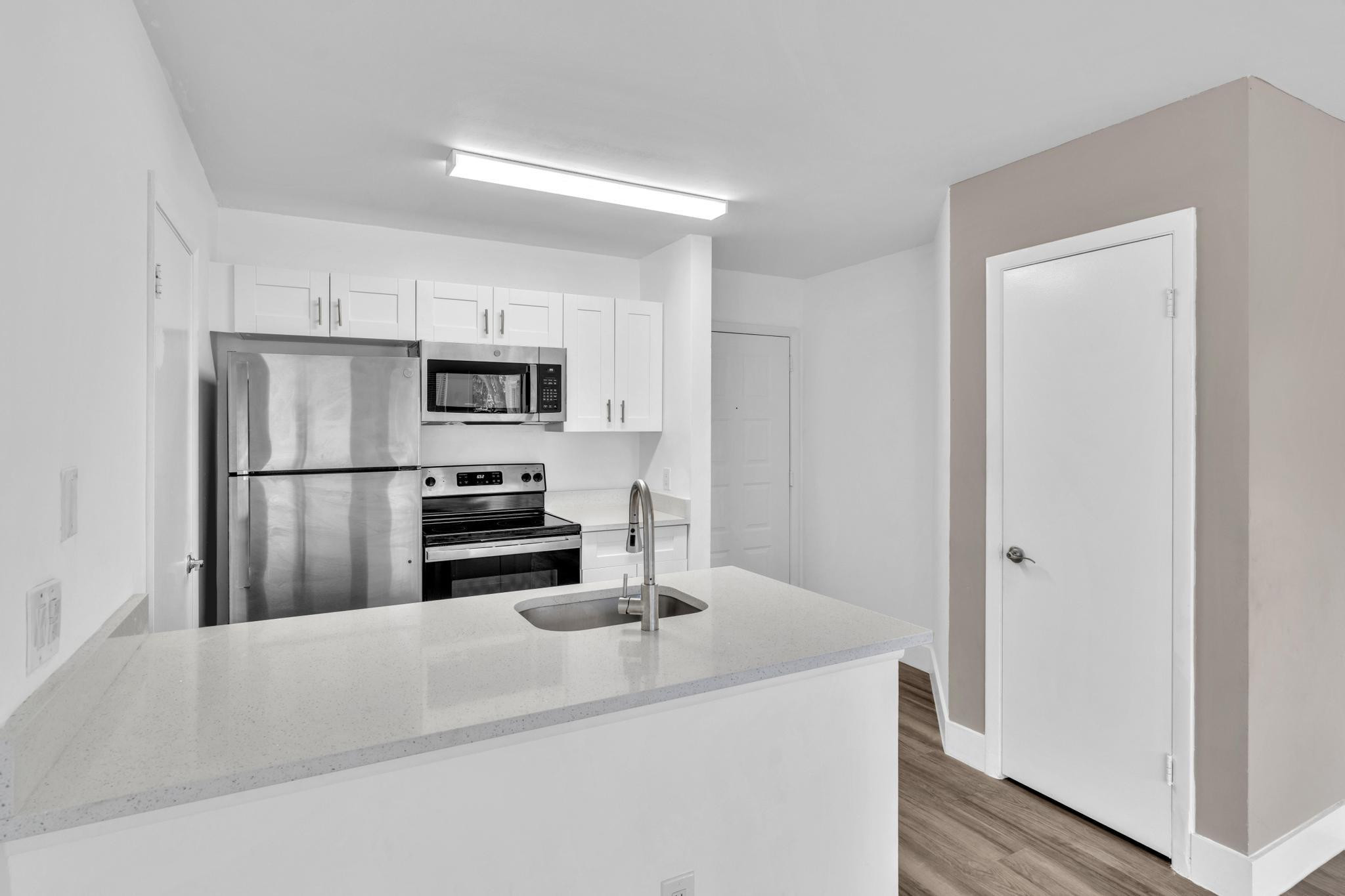 4481 West McNab Road, Unit 28 Pompano Beach, FL 33069 - Photo 12 of 45 a kitchen with stainless steel appliances a sink and refrigerator