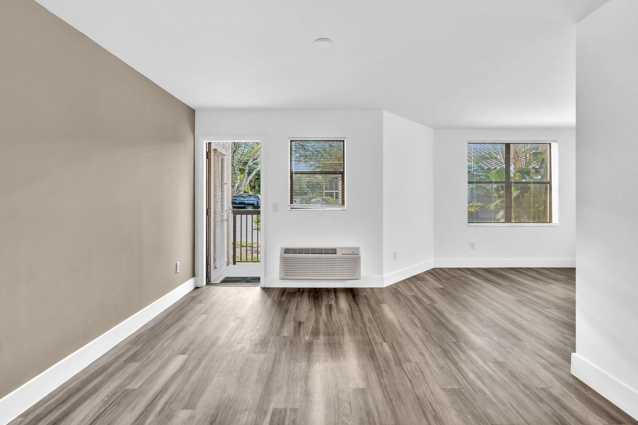 4481 West McNab Road, Unit 28 Pompano Beach, FL 33069 - Photo 14 of 45 an empty room with wooden floor and windows