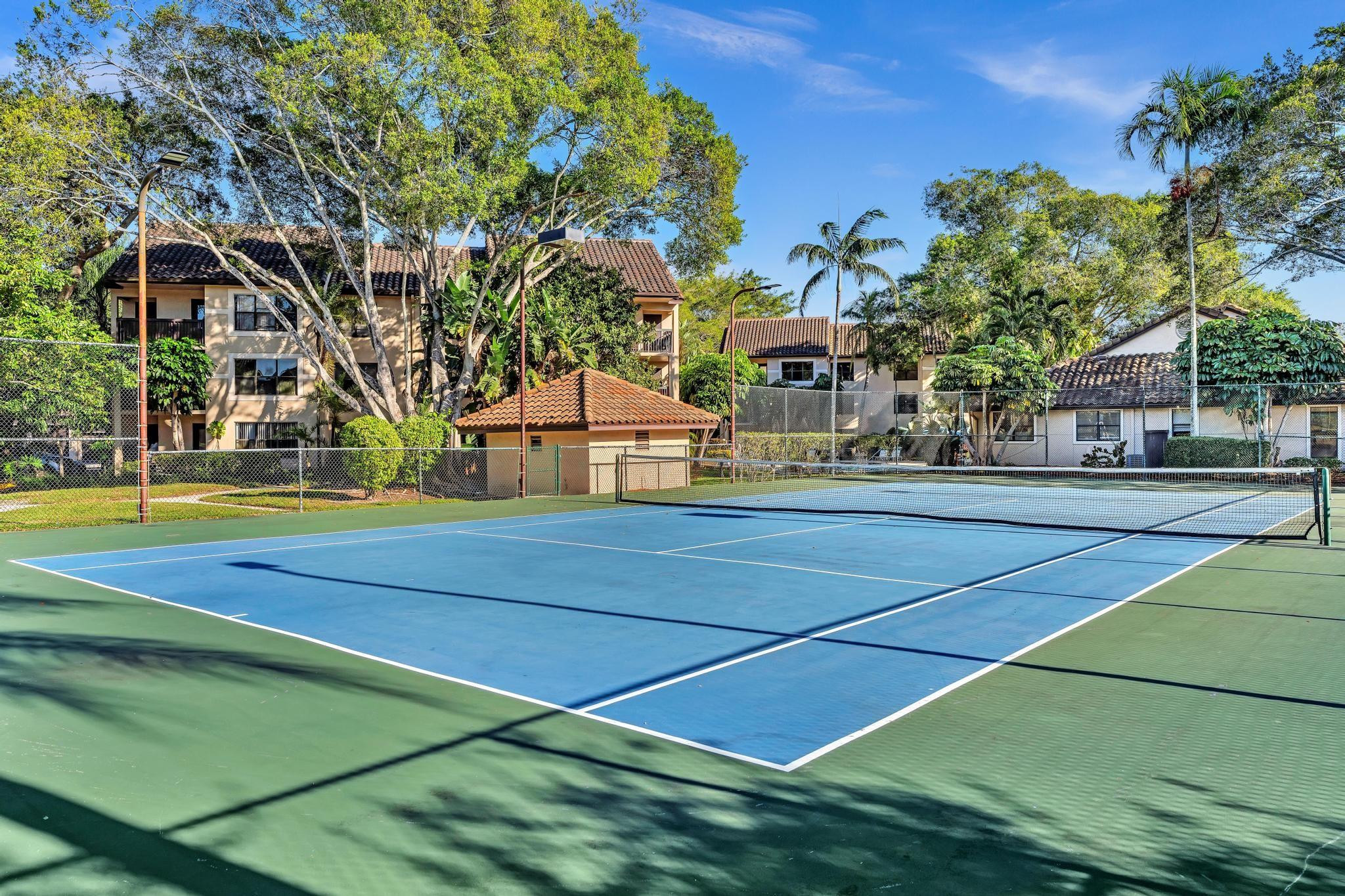 4481 West McNab Road, Unit 28 Pompano Beach, FL 33069 - Photo 34 of 45 a view of a tennis ground with large trees