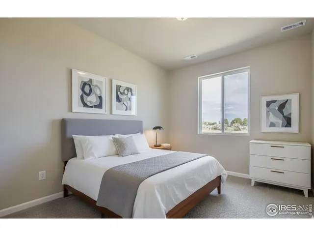 a bedroom with a bed window and chair