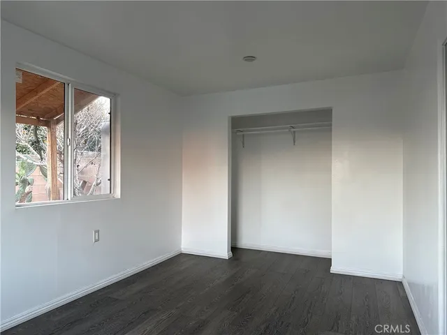 an empty room with a window and a ceiling fan