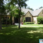 a view of a house with a big yard and large trees