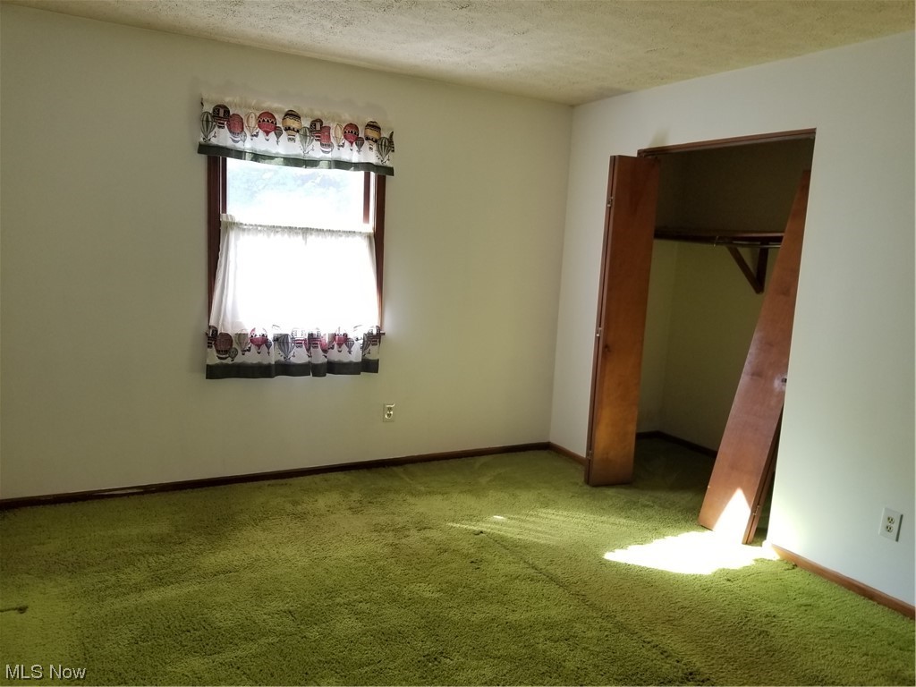 756 Cunningham Road Salem, OH 44460 - Photo 11 of 25 Unfurnished bedroom featuring carpet, a closet, and a textured ceiling