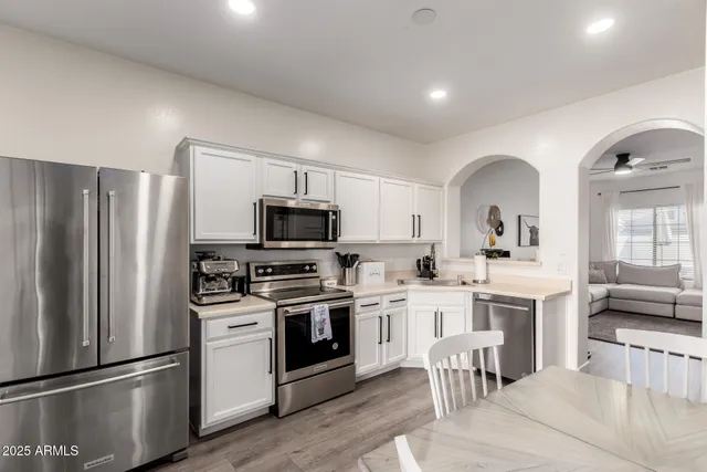 a kitchen with white cabinets and stainless steel appliances