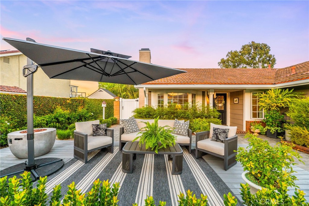 2933 Estancia San Clemente, CA 92673 - Photo 4 of 59 a view of a patio with couches chairs potted plants and a table and chairs under an umbrella