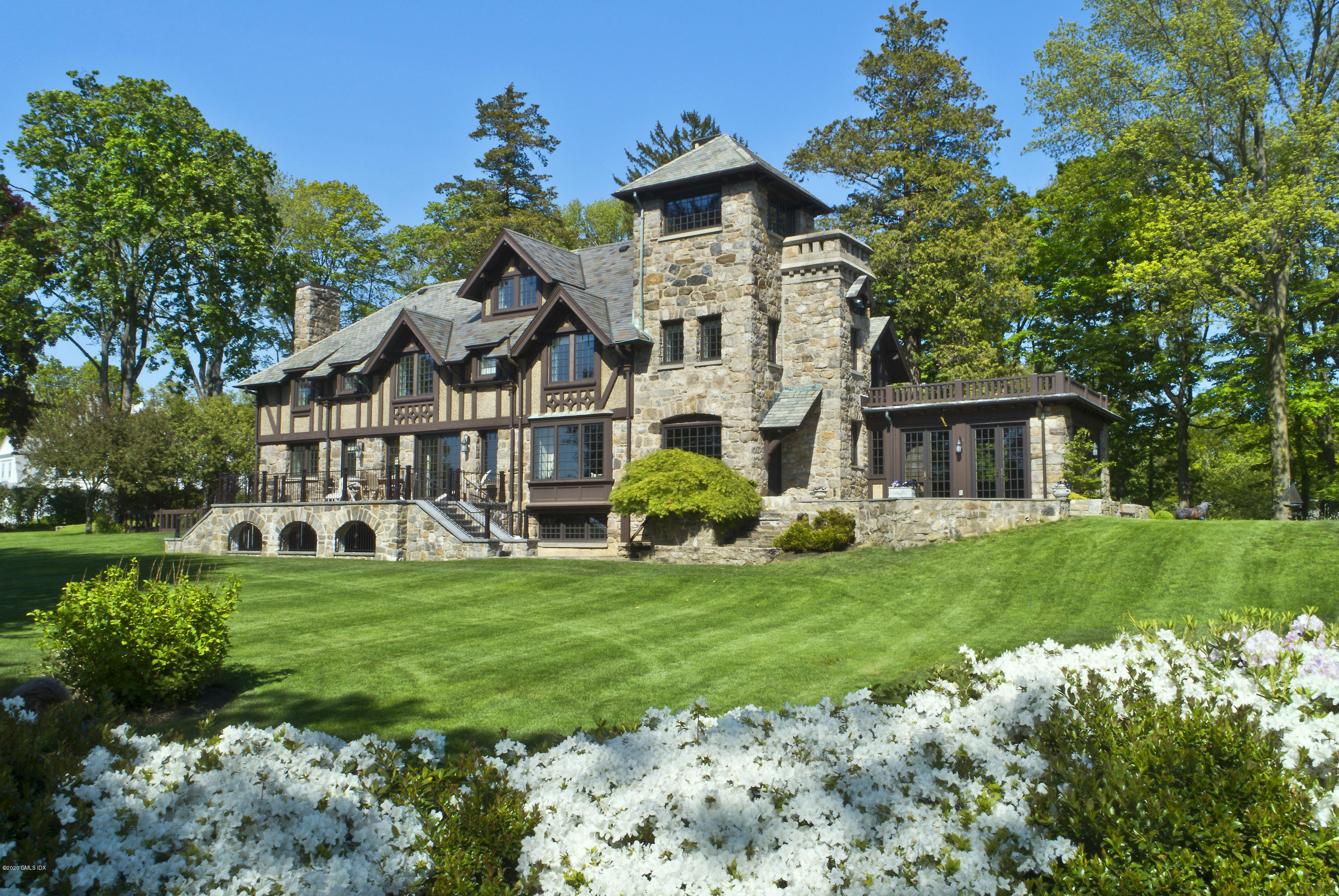 a view of a house with a big yard and large trees