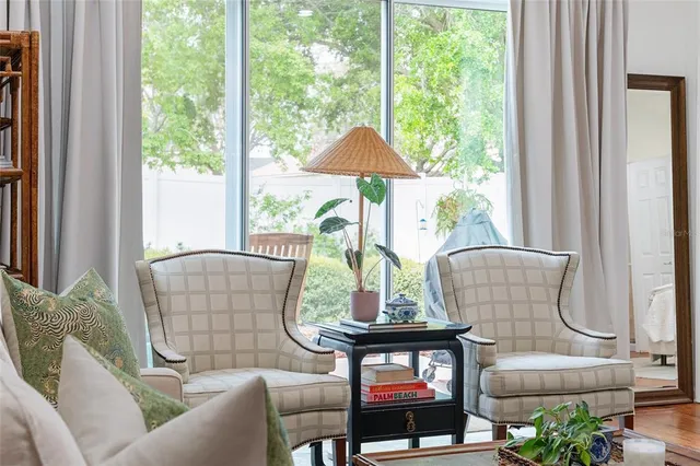 a living room with furniture a table and kitchen view