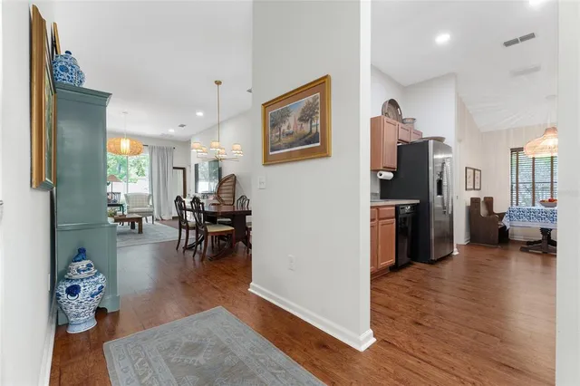 a kitchen with stainless steel appliances granite countertop a refrigerator a sink dishwasher a stove and white countertops with wooden floor