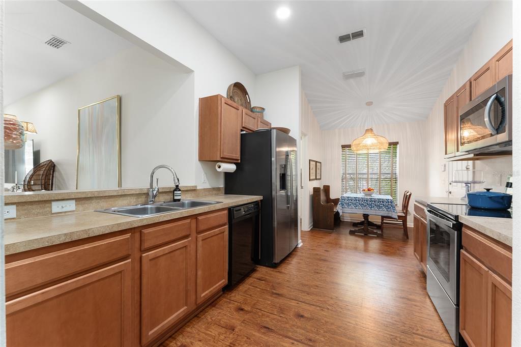4080 Southwest 47th Court Ocala, FL 34474 - Photo 9 of 50 a kitchen with stainless steel appliances granite countertop a refrigerator a sink dishwasher a stove and white countertops with wooden floor