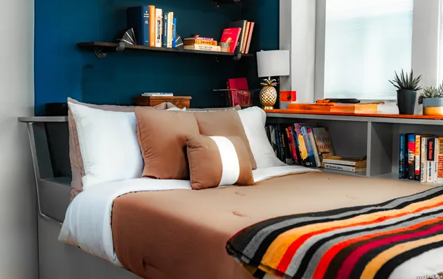 a bedroom with bed and a book shelf