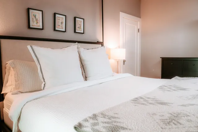 a bedroom with a bed and painting on the wall