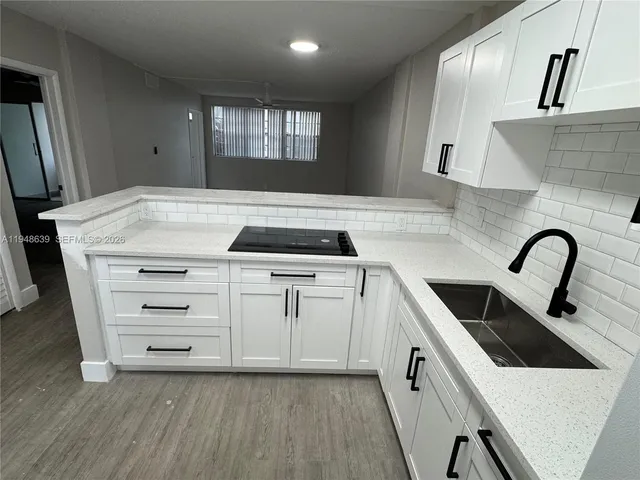 a kitchen with stainless steel appliances granite countertop a refrigerator sink stove and white cabinets