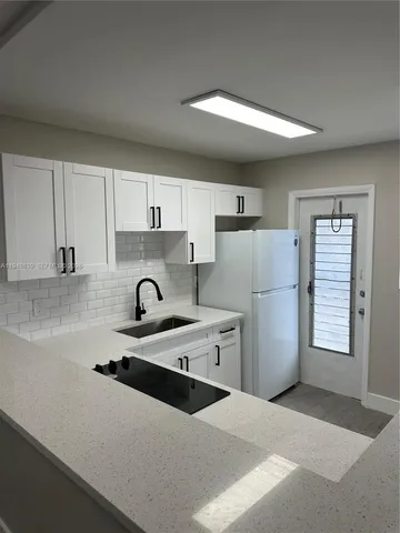 a kitchen with white cabinets and white appliances