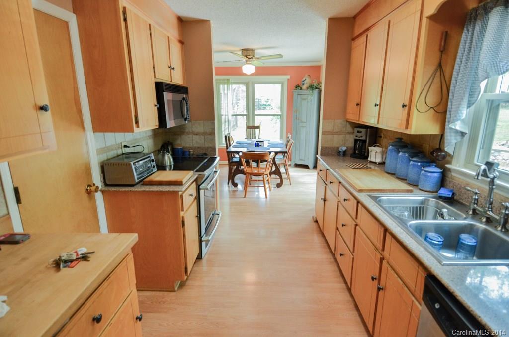 810 Old Williams Road Wingate, NC 28174 - Photo 12 of 24 a kitchen with sink a refrigerator and chairs