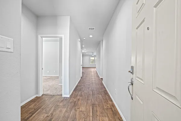 a view of a hallway with wooden floor