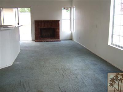 44313 Larrea Street Indio, CA 92201 - Photo 4 of 10 an empty room with a fireplace and windows