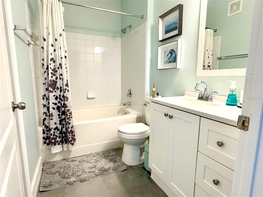 8842 Villa View Circle, Unit 108 Orlando, FL 32821 - Photo 13 of 25 a bathroom with a sink toilet a shower and a mirror