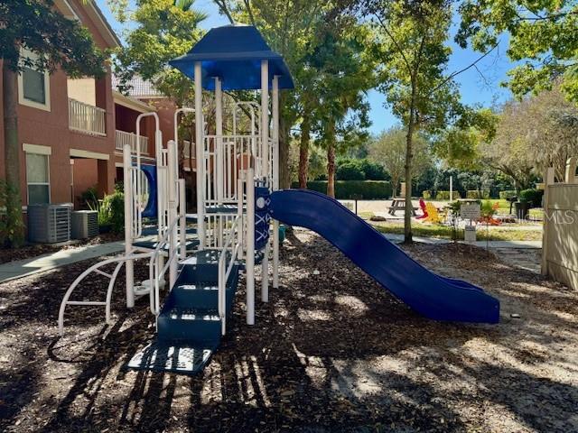 8842 Villa View Circle, Unit 108 Orlando, FL 32821 - Photo 19 of 25 a view of a patio with lawn chairs wooden floor and fence
