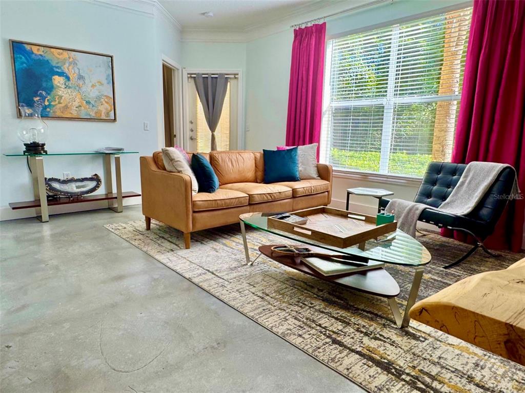 8842 Villa View Circle, Unit 108 Orlando, FL 32821 - Photo 5 of 25 a living room with furniture and a large window
