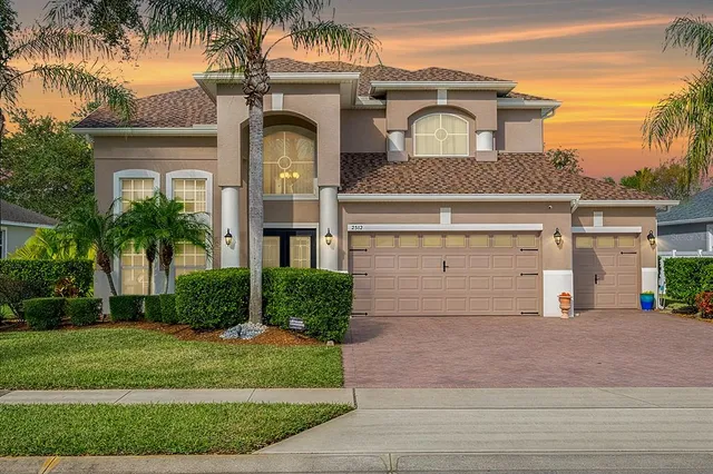 a front view of a house with a garden and plants