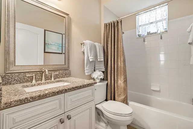 a backyard of a house with table and chairs under an umbrella