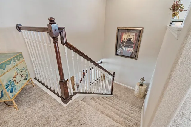 a view of a white house with large windows and a small yard