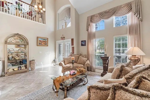 a living room with furniture a chandelier and a flat screen tv