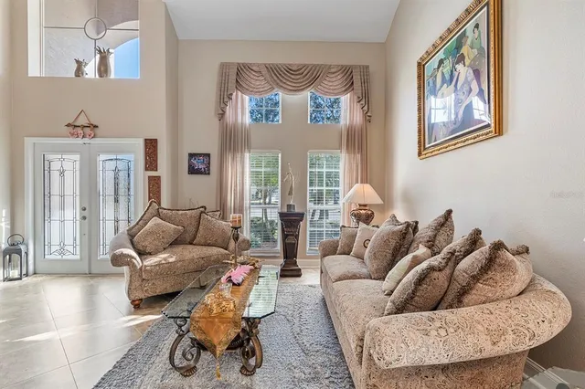 a view of a dining room with furniture a chandelier and a window