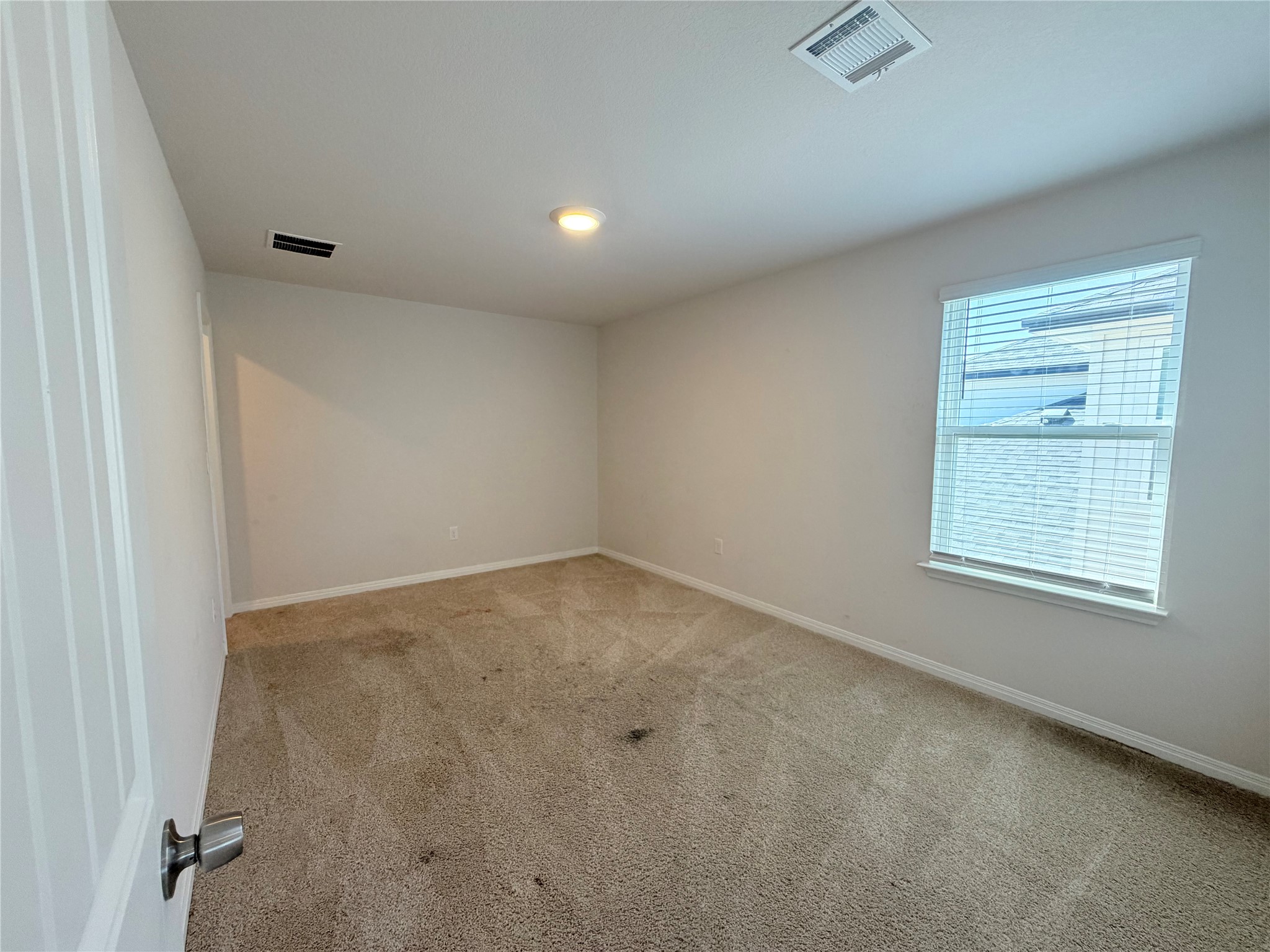 129 Saide Street Georgetown, TX 78626 - Photo 23 of 36 An airy bedroom features neutral walls, plush carpeting, and a large window for natural light.