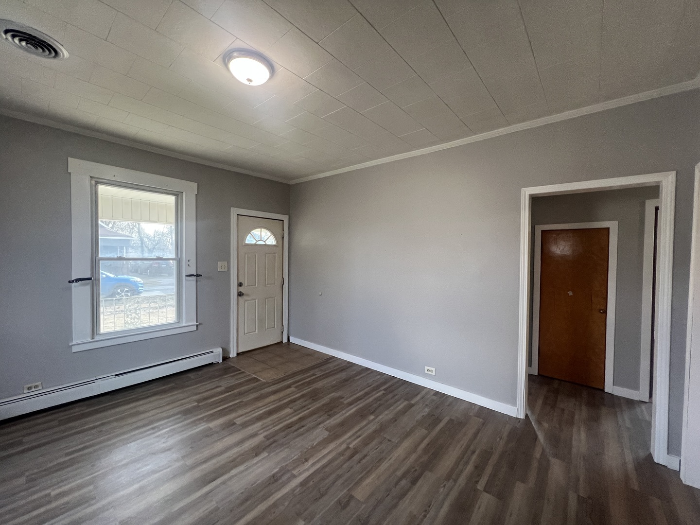 1109 West Adams Street Herrin, IL 62948 - Photo 12 of 27 an empty room with wooden floor and windows