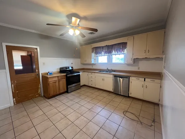 a kitchen with a sink window and cabinets
