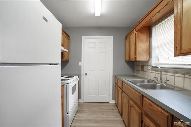 a kitchen with a sink and a refrigerator