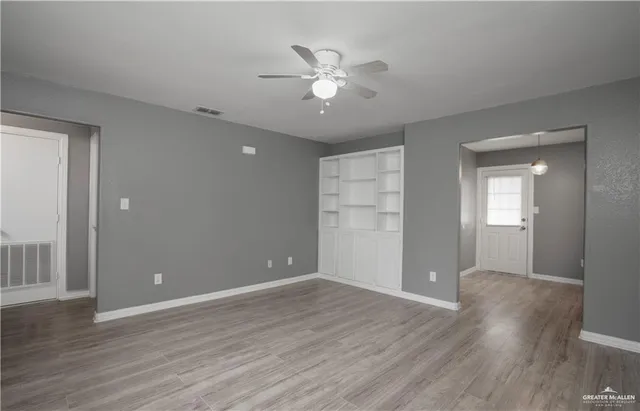 a view of an empty room with wooden floor