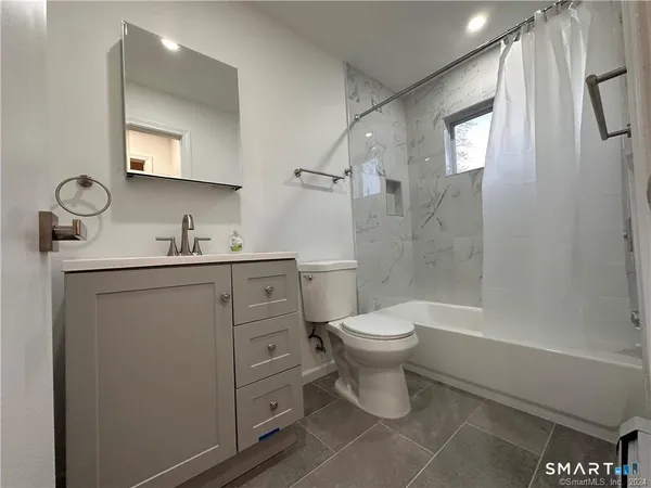 a bathroom with a toilet a sink and a mirror