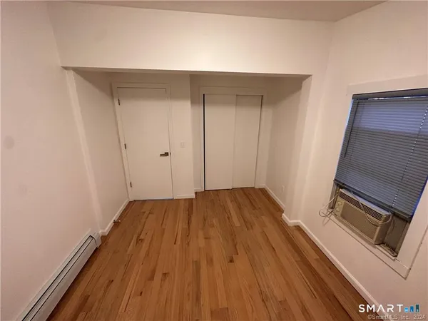 a view of a hardwood floor and an empty room