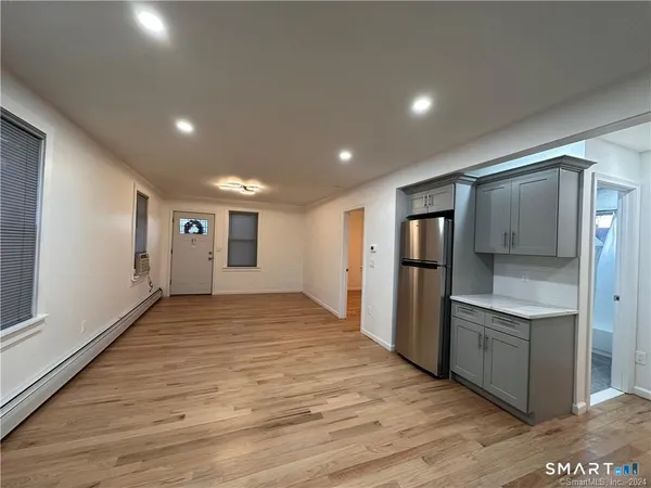 a view of empty room with wooden floor