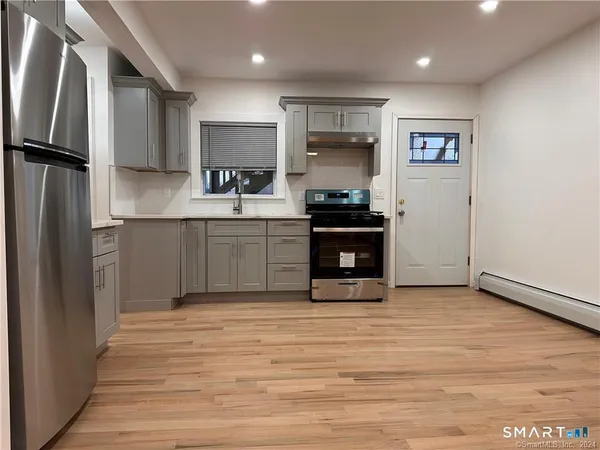 a kitchen with stainless steel appliances granite countertop a refrigerator sink and stove