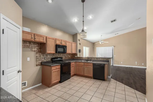 a large kitchen with stainless steel appliances granite countertop a stove and a refrigerator