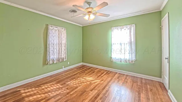 a view of empty room with window and ceiling fan