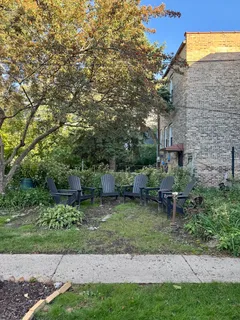 a view of a chair and table in backyard of the house