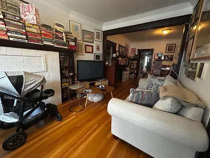 a living room with furniture a flat screen tv and gym equipment