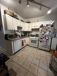 a kitchen with stainless steel appliances a sink a stove top oven a chimney and a center island