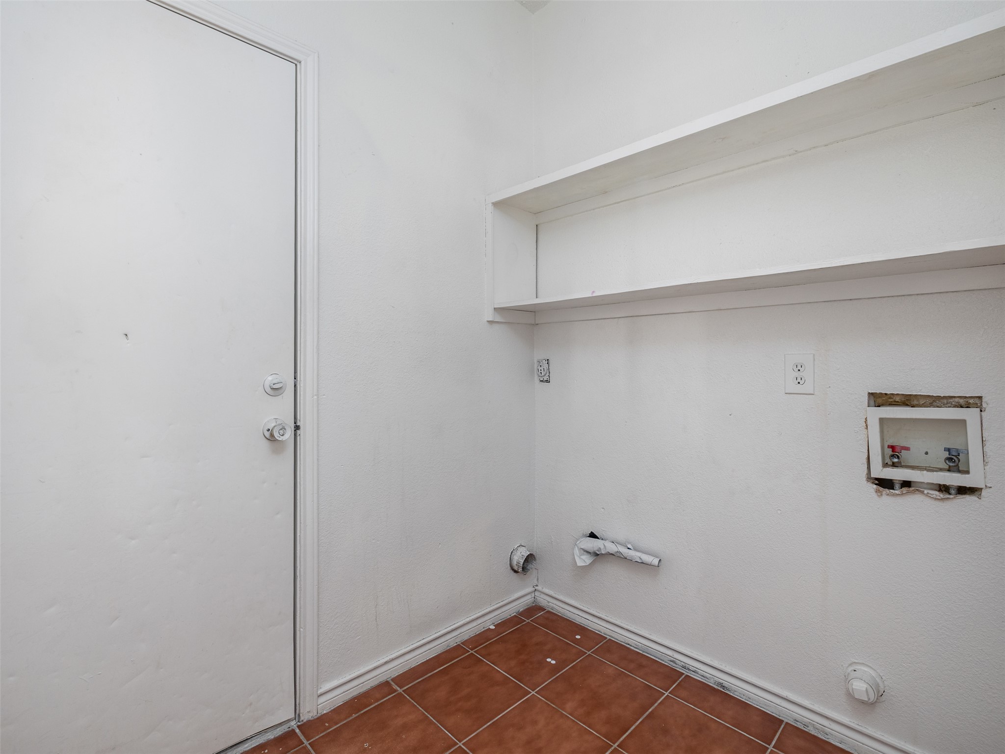 506 Tillery Street Austin, TX 78702 - Photo 16 of 27 Laundry area featuring dark tile patterned floors, hookup for a washing machine, and gas dryer hookup
