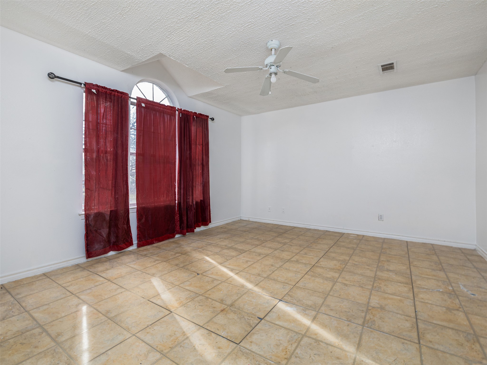 506 Tillery Street Austin, TX 78702 - Photo 7 of 12 Unfurnished room with ceiling fan and a textured ceiling