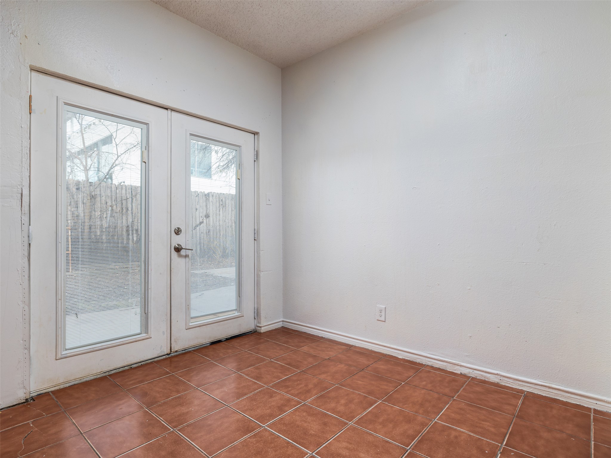 506 Tillery Street Austin, TX 78702 - Photo 8 of 27 Doorway with french doors, a textured ceiling, and tile patterned floors